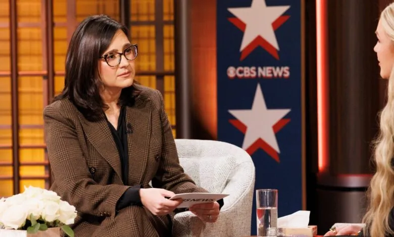 CBS News interview with woman in brown suit and glasses.