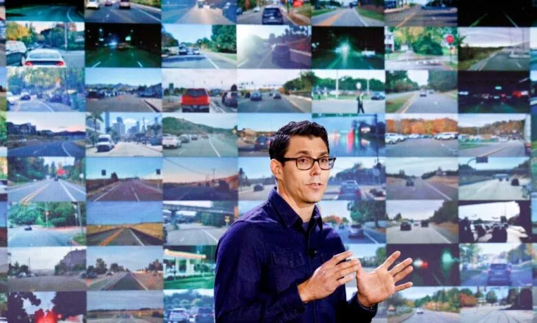 Man presenting in front of a screen displaying road images.