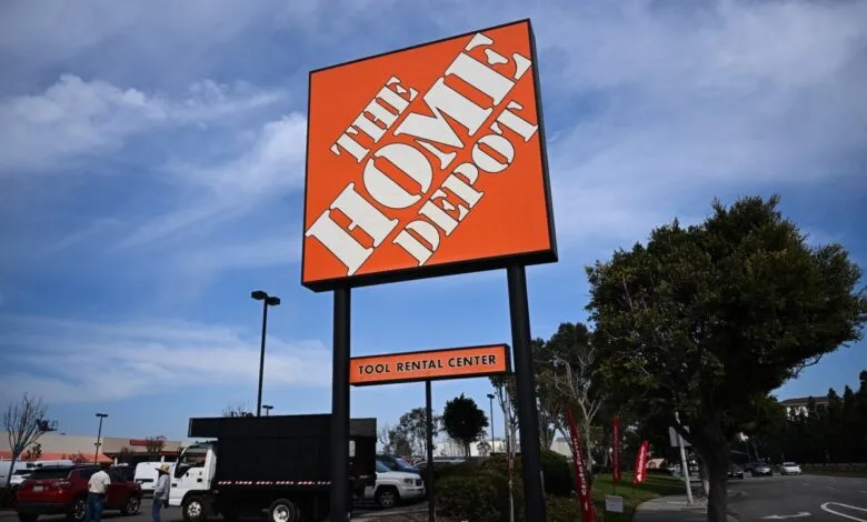 Home Depot store sign with Tool Rental Center under a blue sky.