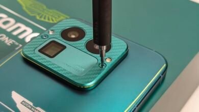 Close-up of a Realme phone with Aston Martin branding being repaired.