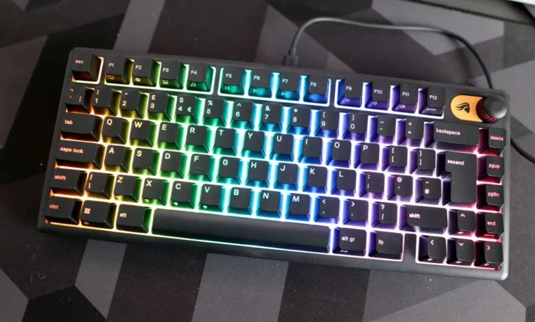 Custom mechanical keyboard with rainbow LED backlighting on a geometric mousepad.