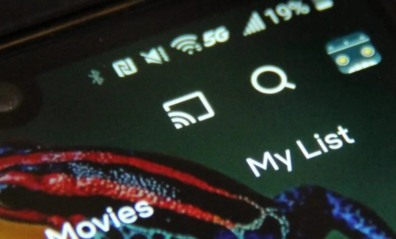 Close-up of phone screen showing 5G, Wi-Fi, and app icons.