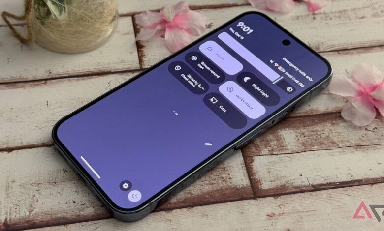 Smartphone displaying quick settings menu on wooden surface.