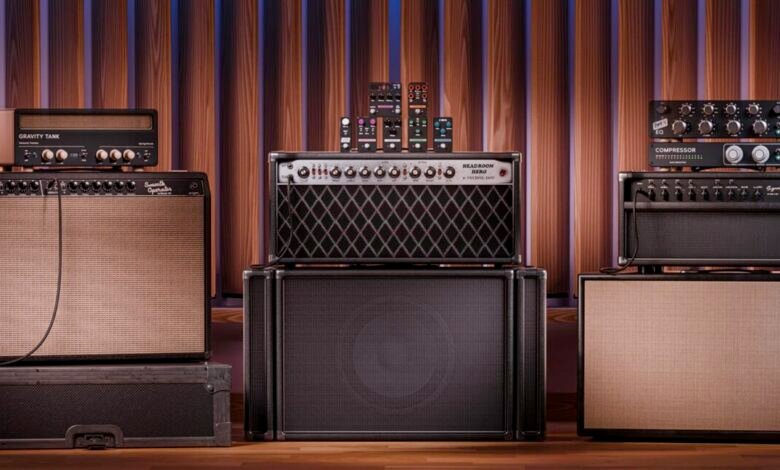 Collection of guitar amplifiers and effects pedals against a wood panel backdrop.