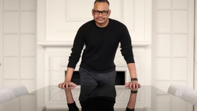 Jyoti Bansal leans on a reflective table in a modern setting.