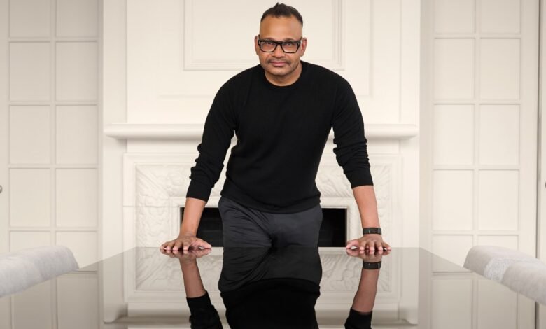 Jyoti Bansal leans on a reflective table in a modern setting.