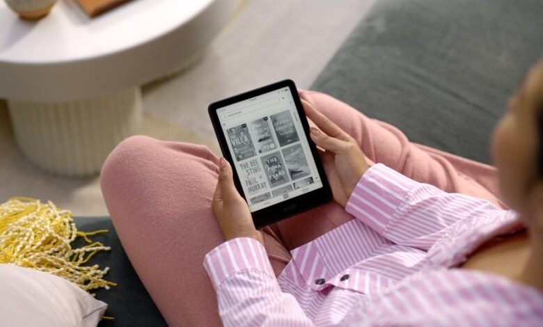 Person relaxing with Kindle e-reader showing book covers.