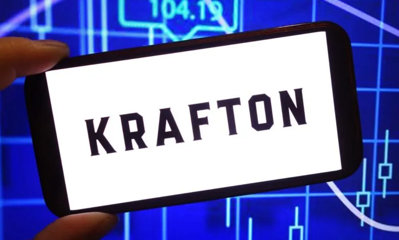 Krafton logo displayed on a smartphone screen with stock chart background.