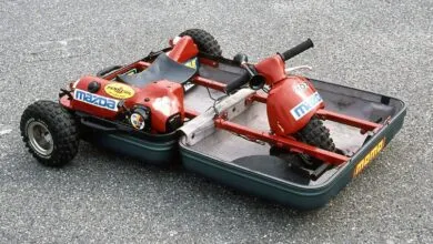 Unique go-kart built inside two suitcases, red frame, Mazda logos.