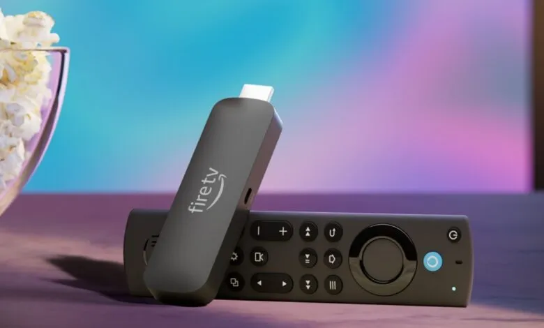 Amazon Fire TV Stick and remote on a table with popcorn in the background.