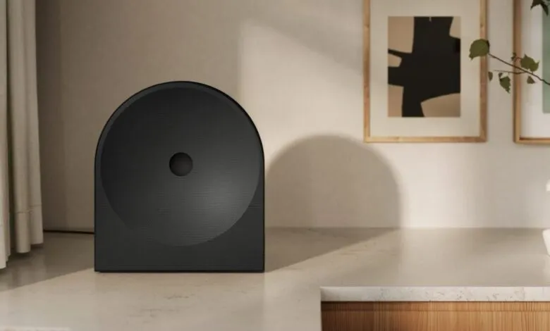 Modern black speaker with rounded top on a light surface.