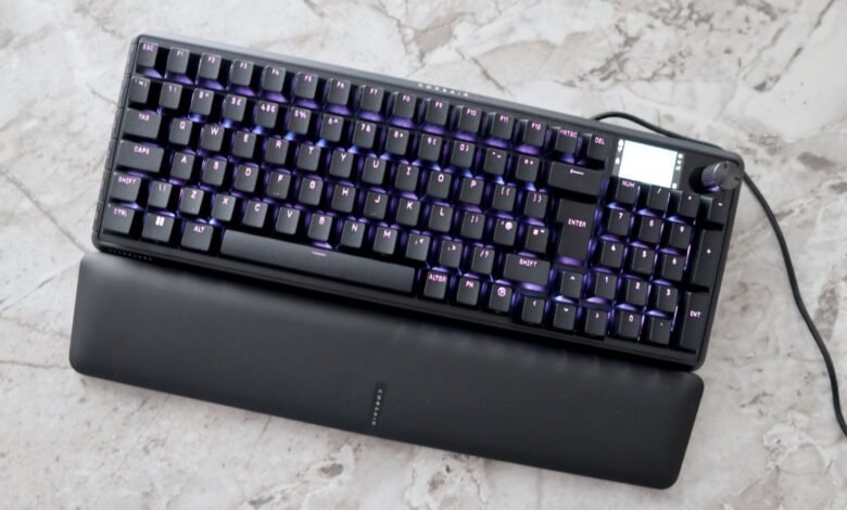 Corsair mechanical keyboard with purple backlighting and wrist rest.