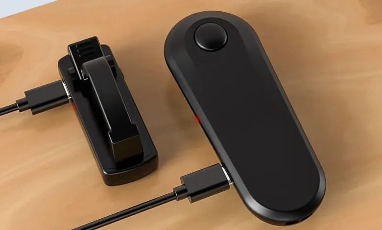 Black page turner device with clip and charging cable on wooden surface.