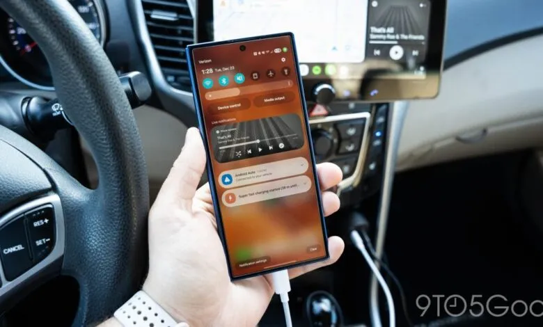 Smartphone connected to Android Auto in car, showing music and charging.