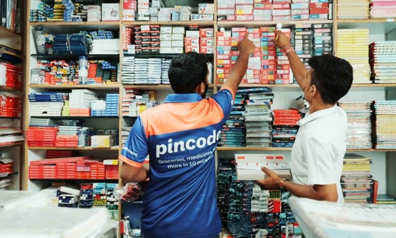 Two men stock shelves in a well-stocked retail store.