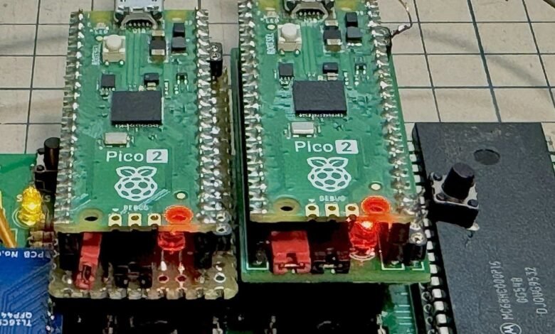 Two Raspberry Pi Pico 2 boards connected to a circuit board with wires and components.