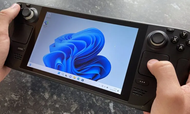 Hands holding a Steam Deck running Windows 11, showing the desktop.