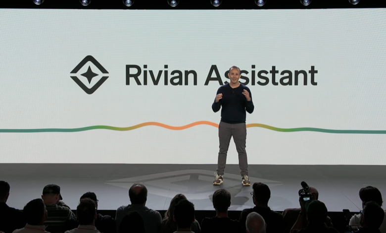 Presenter on stage at Rivian Assistant event, audience in foreground.