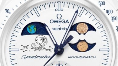 Close-up of Omega x Swatch MoonSwatch watch face with Snoopy and Earth/Moon phases.