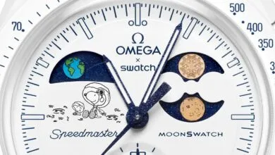 Close-up of Omega x Swatch MoonSwatch watch face with Snoopy and Earth/Moon phases.