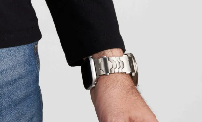 Close-up of a wrist wearing a silver Apple Watch with a metal band.