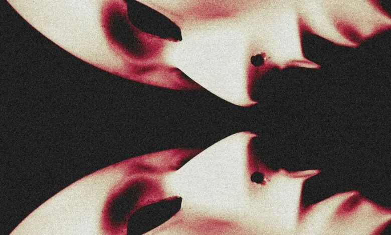 Abstract image of two pale masks with red accents against a dark background.