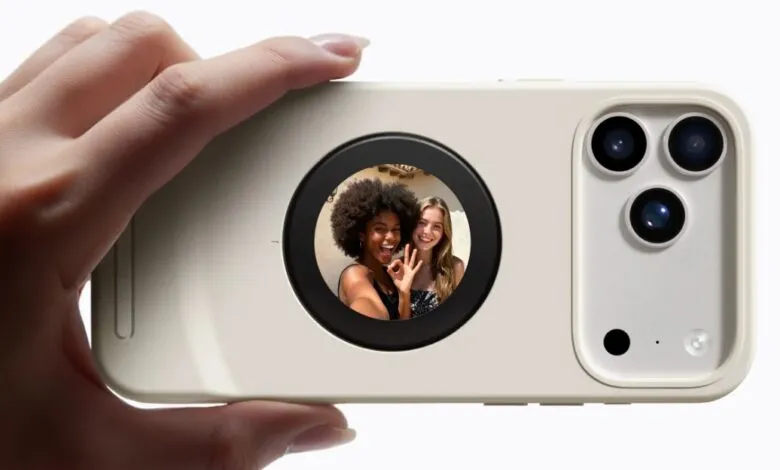 Hand holding phone case with built-in screen showing two smiling women.