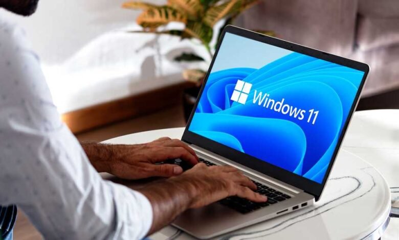 Person typing on laptop displaying the Windows 11 operating system.