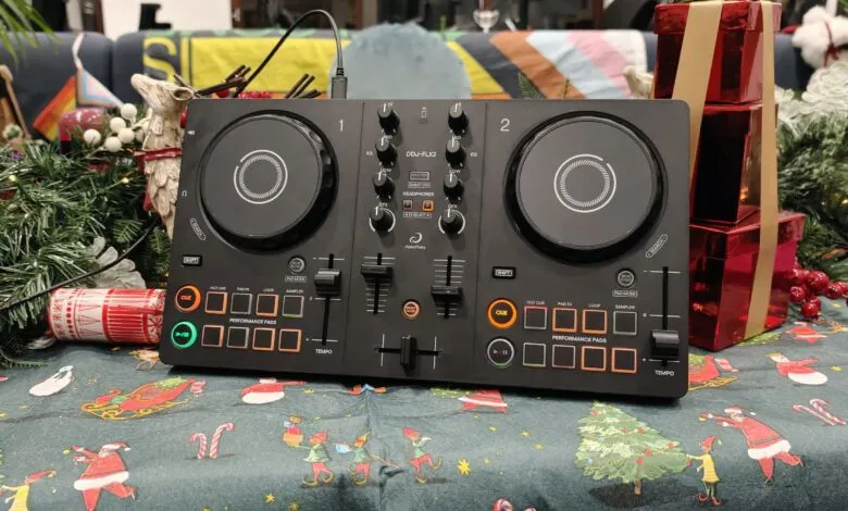 AlphaTheta DJ controller on a Christmas-themed tablecloth with decorations.