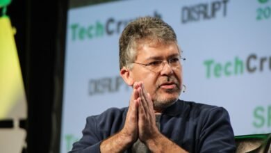 John Giannandrea at TechCrunch Disrupt, hands clasped, speaking.