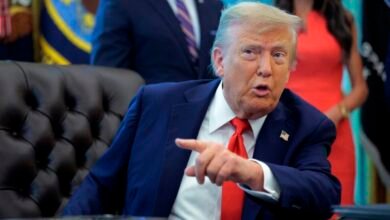 Donald Trump gestures while seated in the Oval Office.
