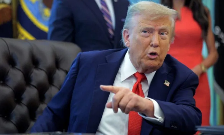 Donald Trump gestures while seated in the Oval Office.