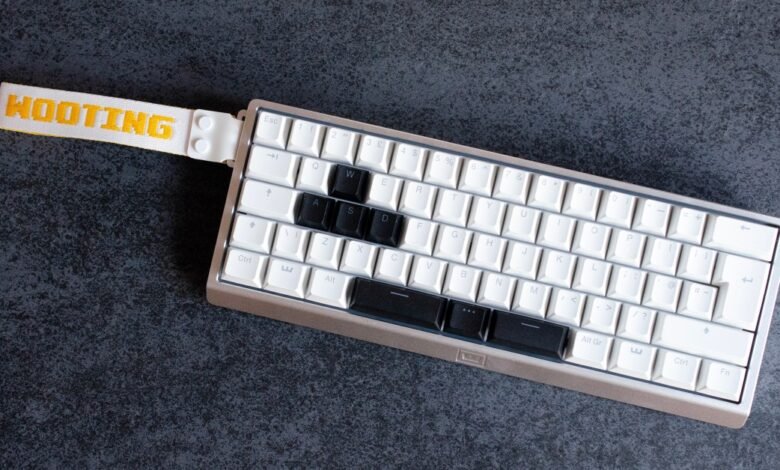 Wooting 60HE keyboard with custom keycaps and wrist strap.