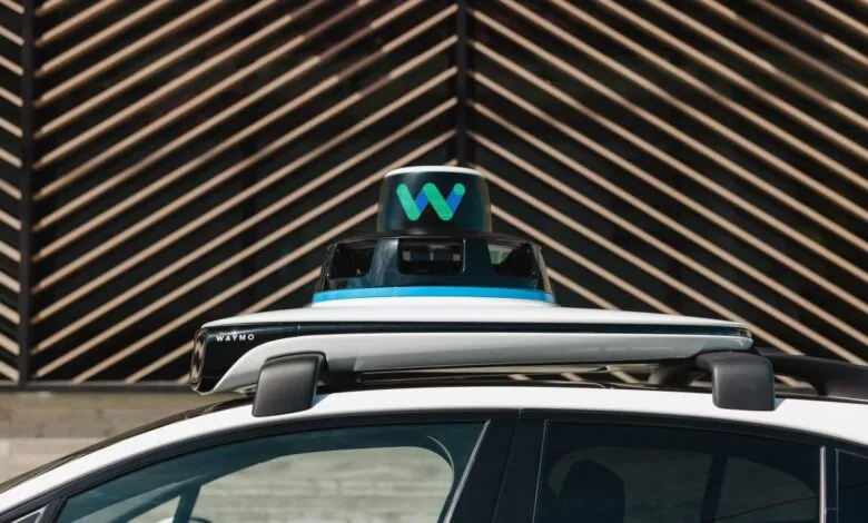 Close-up of Waymo self-driving car sensor on vehicle roof.
