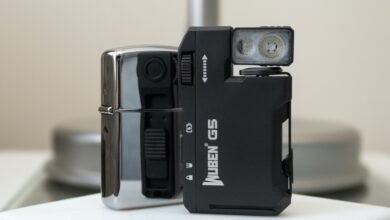 Wuben G5 flashlight next to a chrome lighter on a white surface.