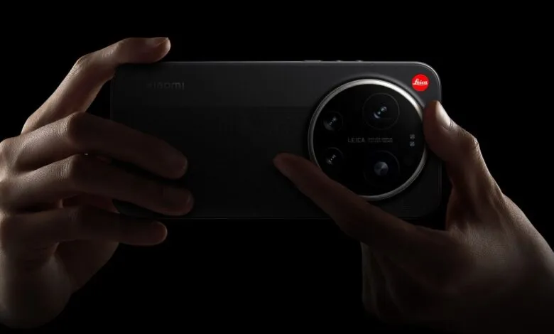 Hands hold a Xiaomi phone with a large, circular Leica camera module on a black background.