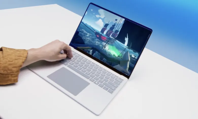 Person playing Sea of Thieves on a white laptop, finger on keyboard.