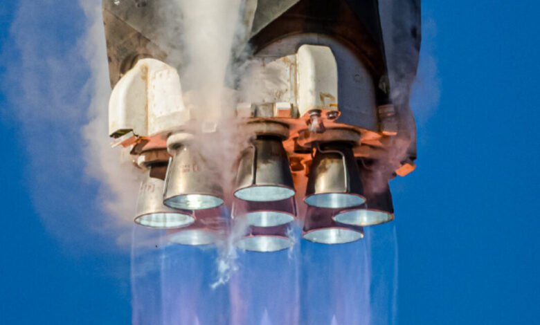 Rocket engines firing with exhaust plumes against a blue sky.