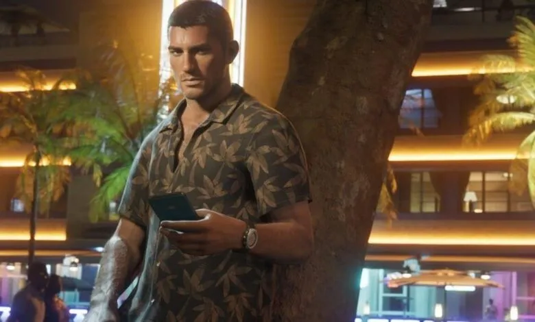 Man in tropical shirt holds phone by tree at night.
