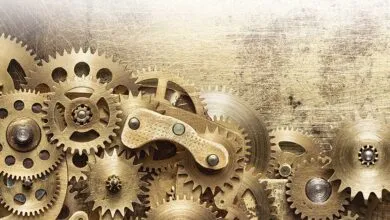 Close-up of intricate gold gears and cogs against a textured background.