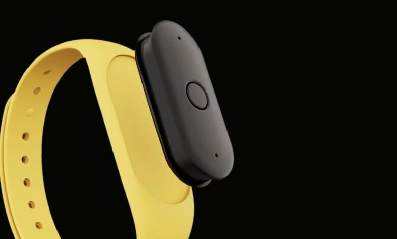 Fitness tracker with yellow band and black module on a black background.