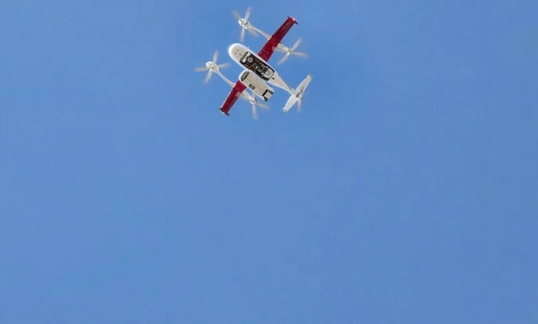 Zipline drone flying in a clear blue sky, viewed from below.
