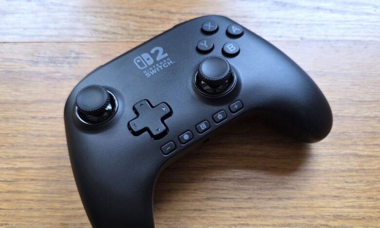 Black Nintendo Switch controller on a wooden surface, angled view.
