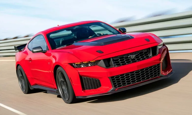 Red 2024 Ford Mustang Dark Horse driving on a track, front angle.