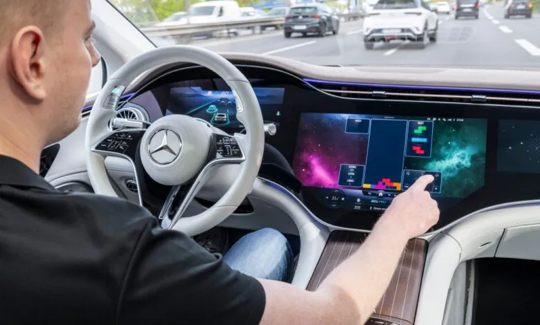 Driver interacts with large touchscreen in Mercedes EQS electric car.
