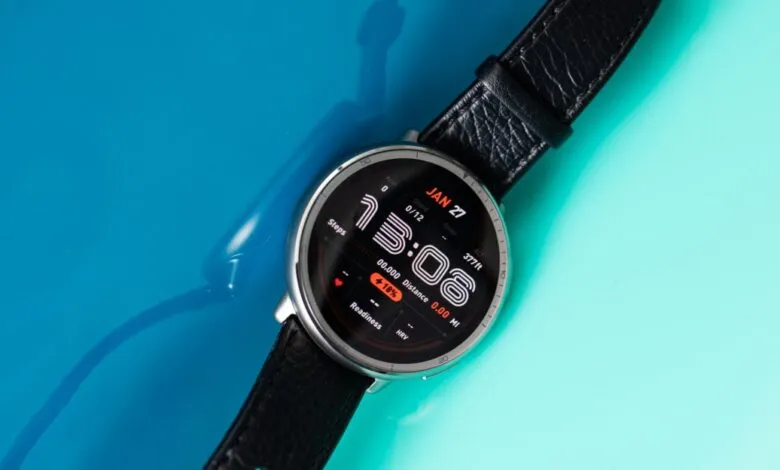 Smartwatch with black leather band displaying fitness data on a colorful background.