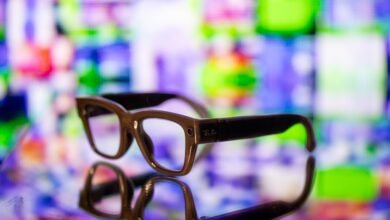 Ray-Ban smart glasses on reflective surface with colorful background.