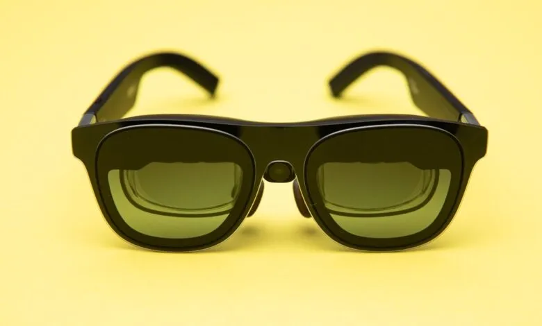 Black XREAL Air 1S AR glasses on a bright yellow background.