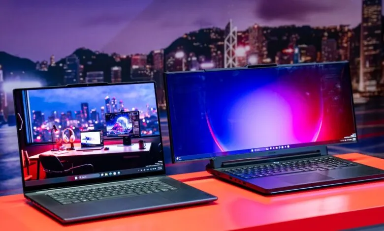 Two Lenovo Legion Pro laptops on a red surface, city skyline background.