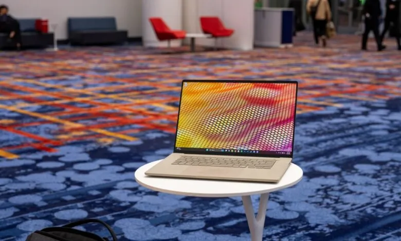 Asus Zenbook laptop on a white table with a colorful screen display.